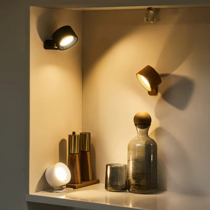 Two cordless wall lamps in a wall niche with a glass bottle and vases | Casa Norex