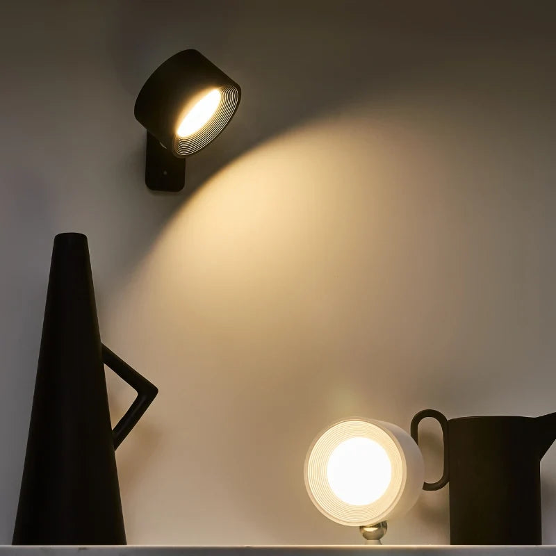 Black cordless wall lamp above a black jug on a white surface — Casa Norex