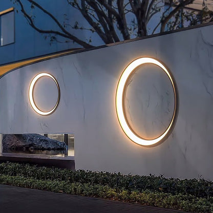 Round outdoor wall light on garden wall along a pathway — Casa Norex