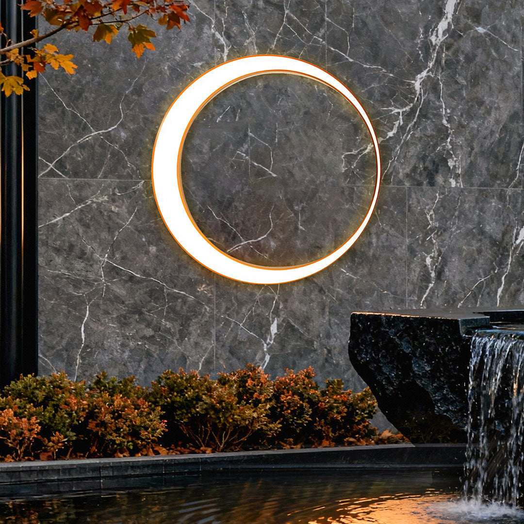 Round outdoor wall light beside stone wall and water feature | Casa Norex