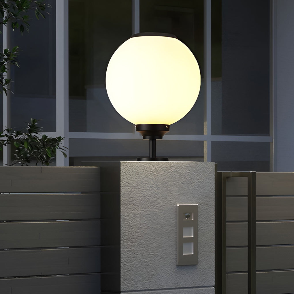 Orbit round solar outdoor pillar light soft glow on a patio in the evening
