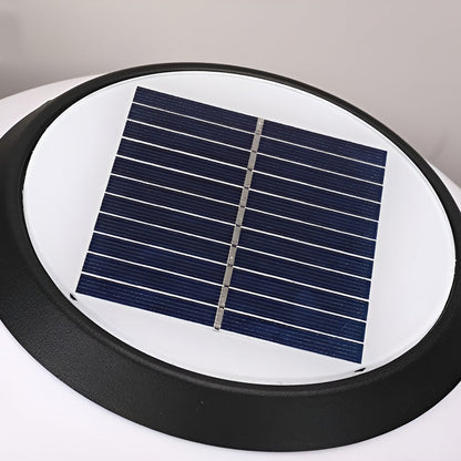 Orbit round solar outdoor pillar light warm light at a garden entrance
