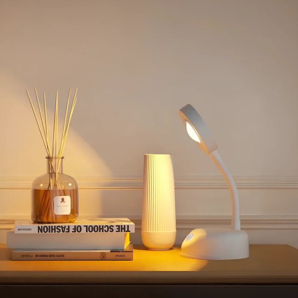 White adjustable lamp head on a tabletop beside a reed diffuser and books — Casa Norex