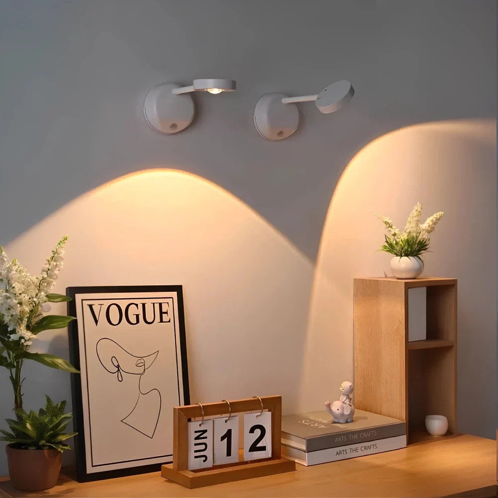 Two white spotlights above a framed print and a desk calendar — Casa Norex