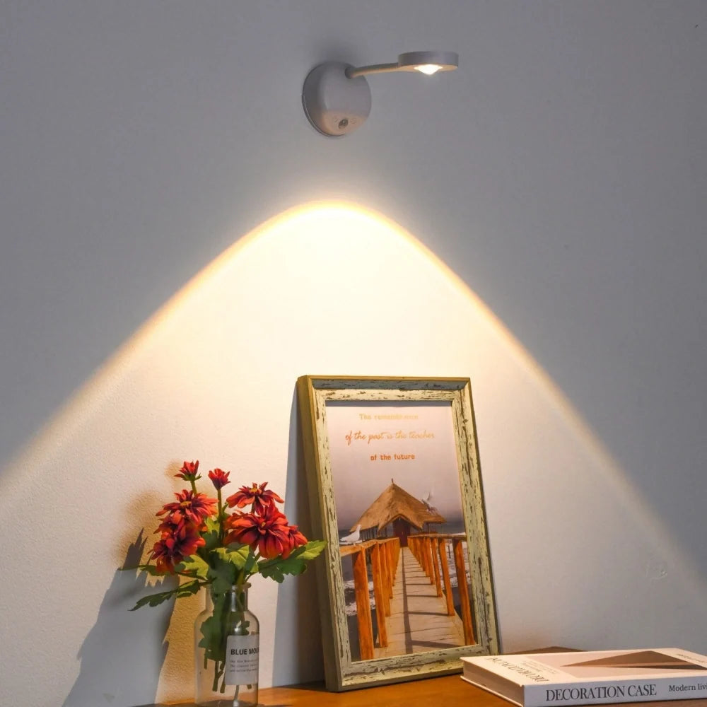 White spotlight above a framed pier photo and red flowers — Casa Norex