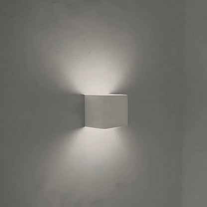 White cube wall light with a cool white glow on a gray wall — Casa Norex