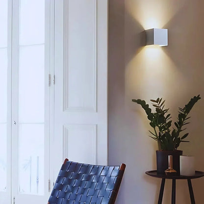 White cube wall light beside a window and chairs — Casa Norex