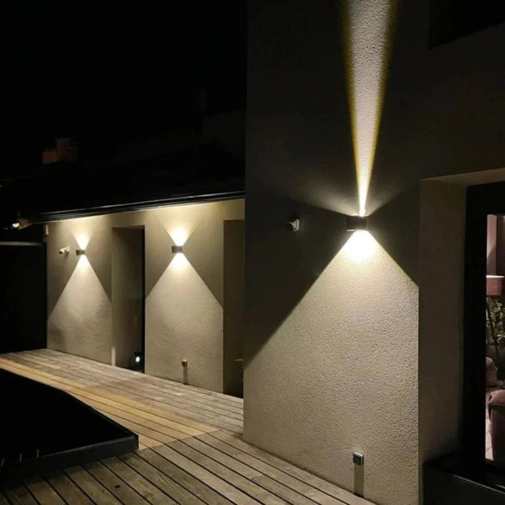 Row of cube wall lights along a wooden deck wall at night — Casa Norex