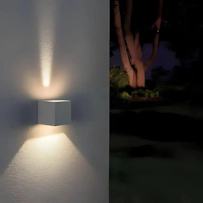 Narrow vertical beam of light on a wall beside trees — Casa Norex