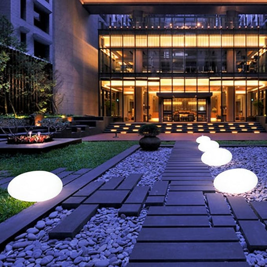 White glowing garden stones along a pathway beside a modern building | Casa Norex
