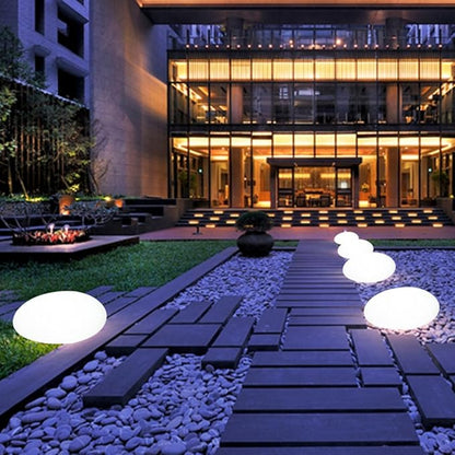 White glowing garden stones along a pathway beside a modern building | Casa Norex