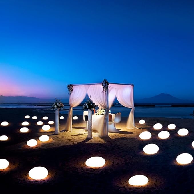 Warm glowing stone lights scattered around a white canopy at dusk | Casa Norex