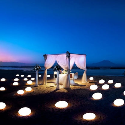 Warm glowing stone lights scattered around a white canopy at dusk | Casa Norex