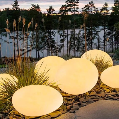 Cluster of large warm white stone lights among grasses and gravel — Casa Norex