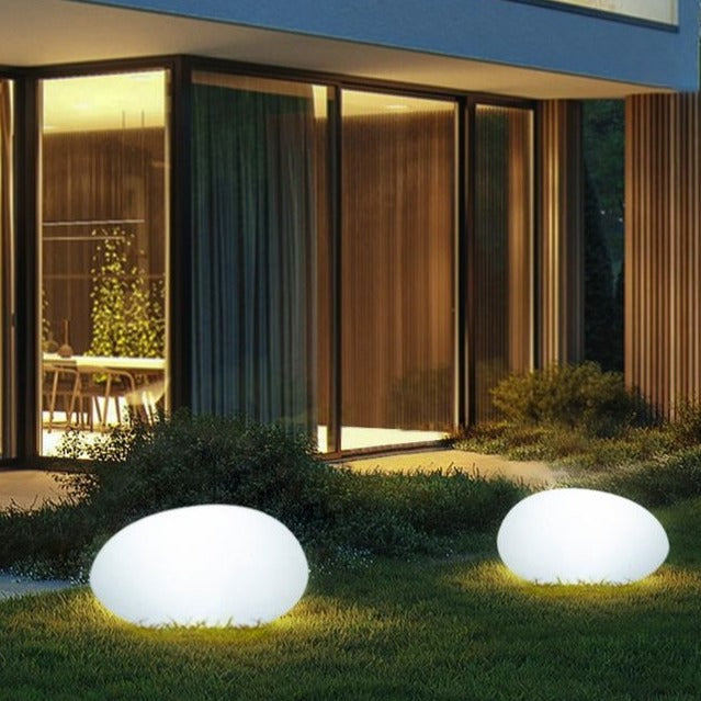 White stone lights on the grass outside glass patio doors — Casa Norex