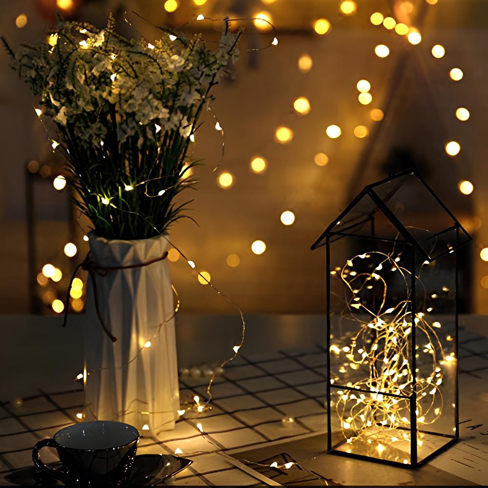 Warm white fairy lights in a glass cloche and scattered across a table — Casa Norex