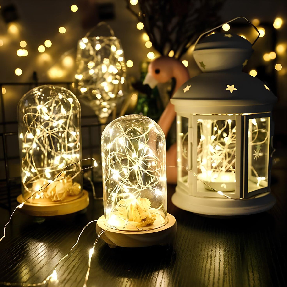 Fairy lights glowing in glass domes and a white lantern on a dark table — Casa Norex