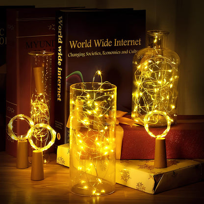 Warm white fairy lights in glass bottles stacked with books — Casa Norex