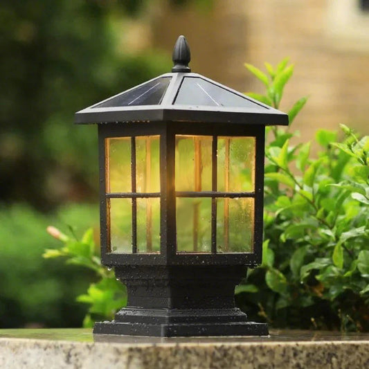 Traditional outdoor pillar light Wren, black lantern lighting a path through greenery | Casa Norex