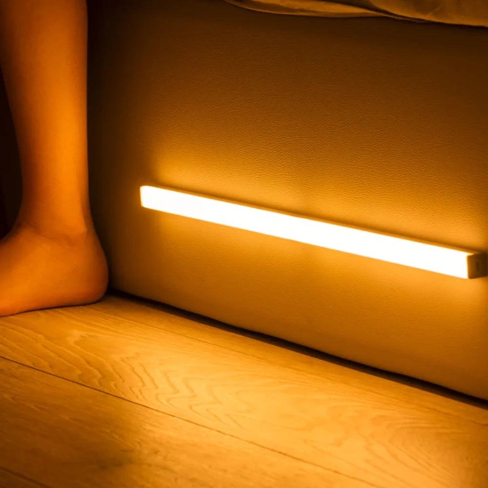 Motion sensor night light bar glowing along the base of a bed | Casa Norex