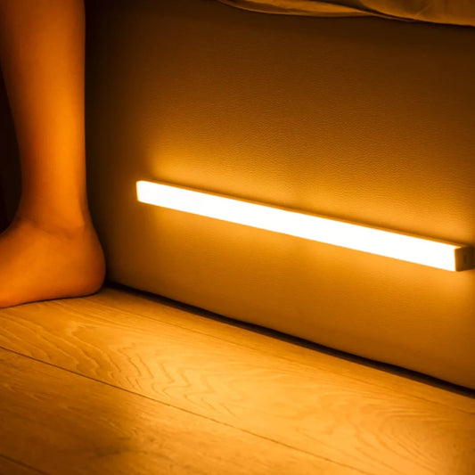 Motion sensor night light bar glowing along the base of a bed | Casa Norex