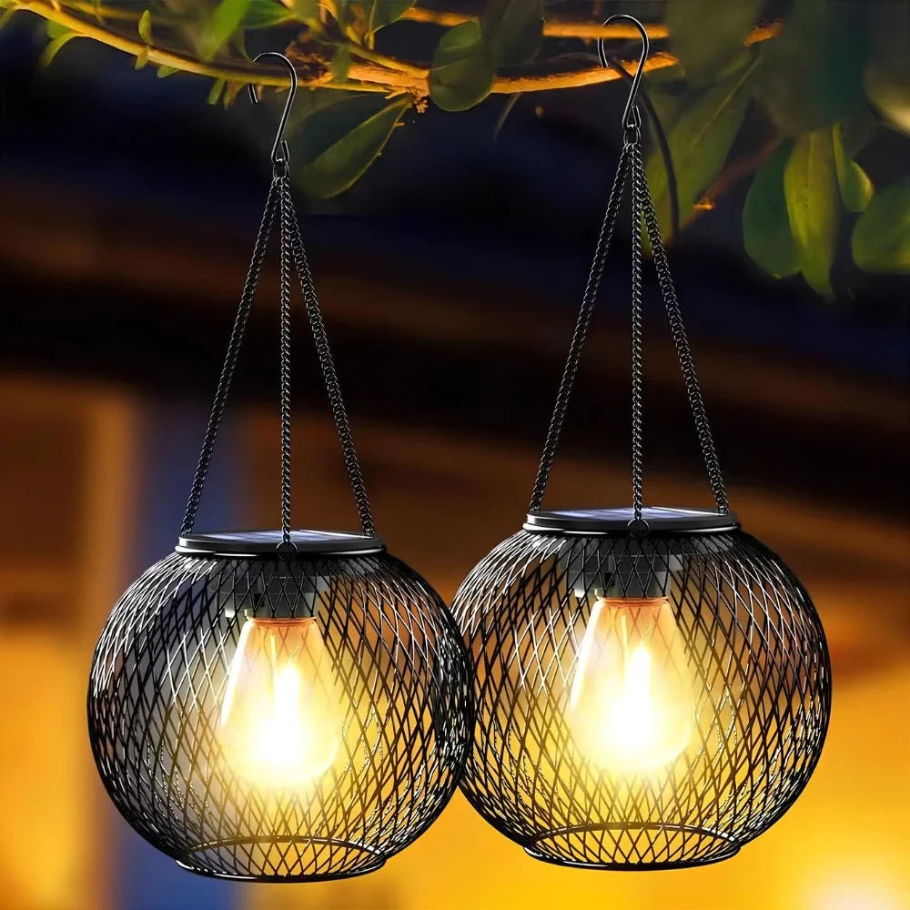 Two round mesh lanterns hanging from chains and glowing warm white — Casa Norex
