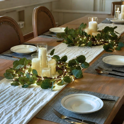 Olive leaf garland lights with candles on a dining table — Casa Norex