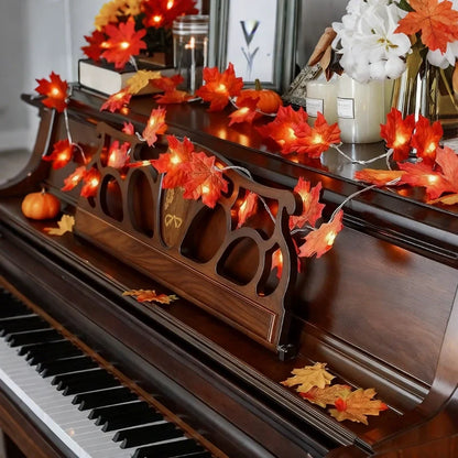 Autumn maple garland lights draped across a piano — Casa Norex
