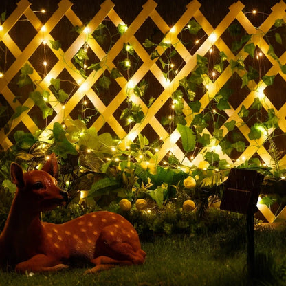 Garland lights on a lattice fence with a decorative deer in a garden — Casa Norex