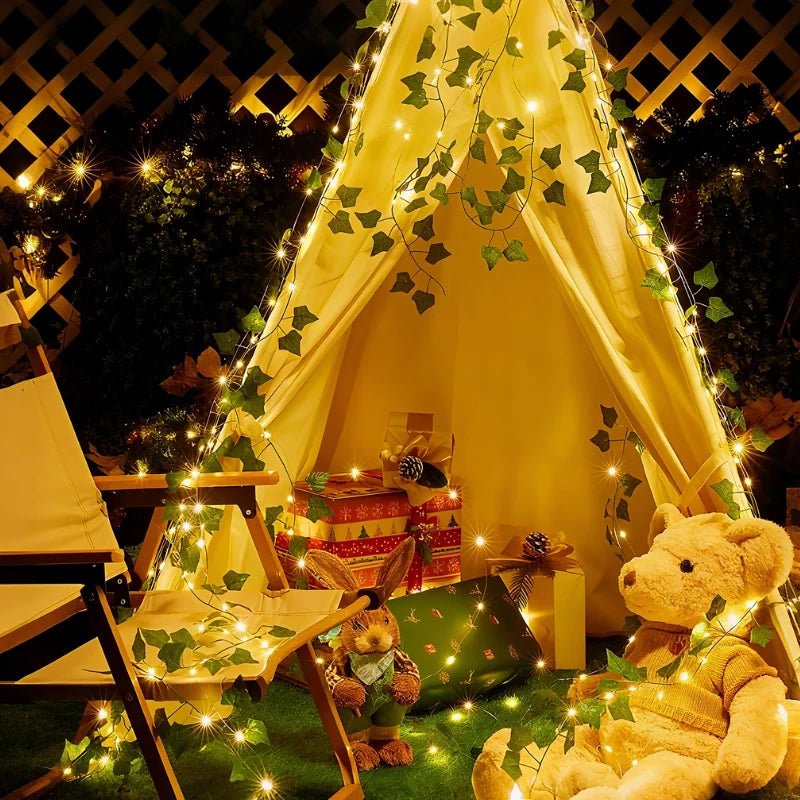 Garland lights lining a tepee tent with cushions at night — Casa Norex