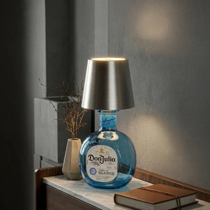 Silver cordless bottle lamp on a blue glass bottle on a gray shelf — Casa Norex