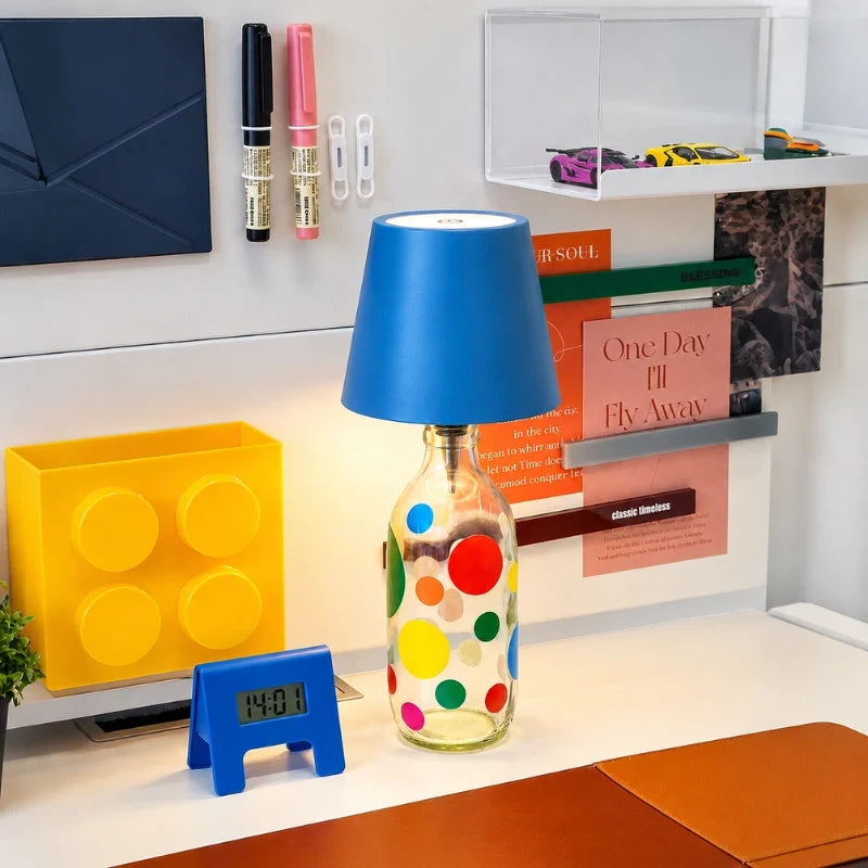 Blue cordless bottle lamp on a dotted bottle on a desk — Casa Norex