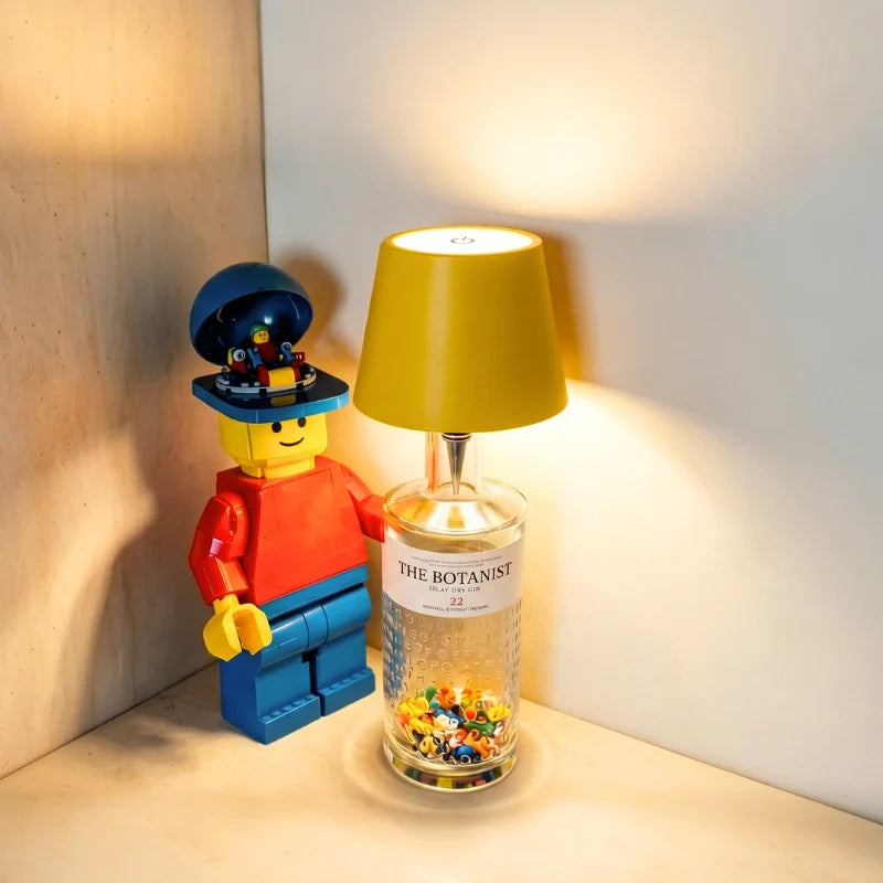 Yellow cordless bottle lamp on a glass jar in a shelf corner — Casa Norex