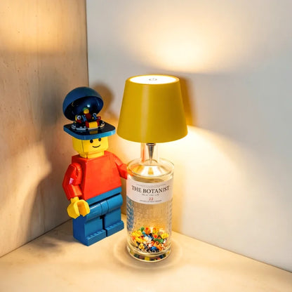Yellow cordless bottle lamp on a glass jar in a shelf corner — Casa Norex