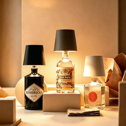 Several black and white cordless bottle lamps on bottles in a warm room — Casa Norex