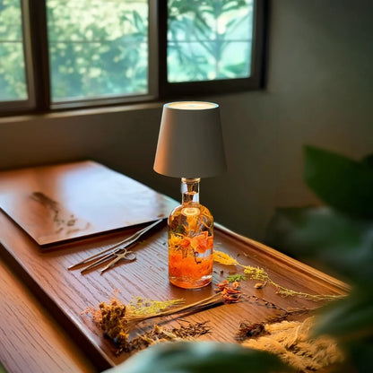 Gray cordless bottle lamp on a bottle on a wooden tray by a window — Casa Norex