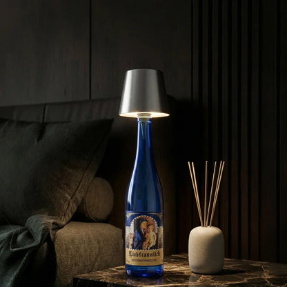 Silver cordless bottle lamp on a blue bottle beside a diffuser — Casa Norex