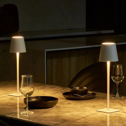 Two lit table lamps beside wine glasses at an evening table — Casa Norex
