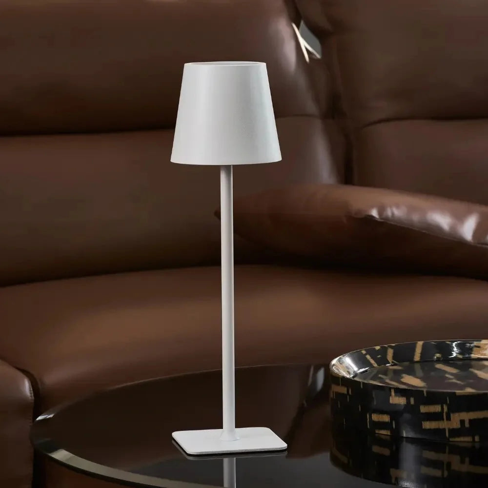 Matte white table lamp in front of a brown leather sofa — Casa Norex